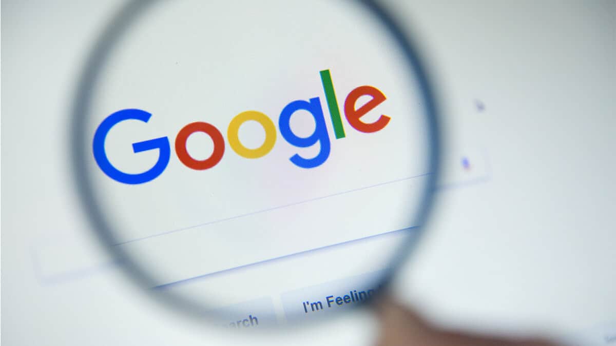 pessoa segurando lupa em frente a uma tela com a página do Google