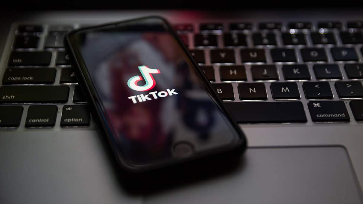 celular em cima de notebook com logo do TikTok