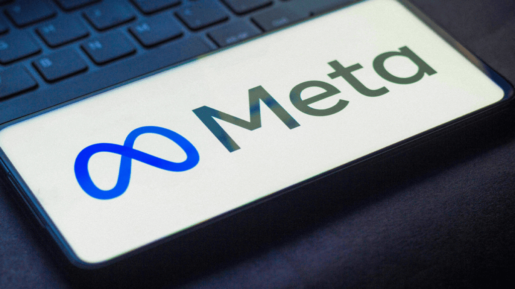 celular em cima de laptop com logo da empresa Meta