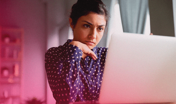 mulher analisando newsletter atrás de computador