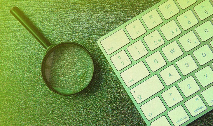 lupa ao lado de teclado indicando pesquisa de palavra-chave